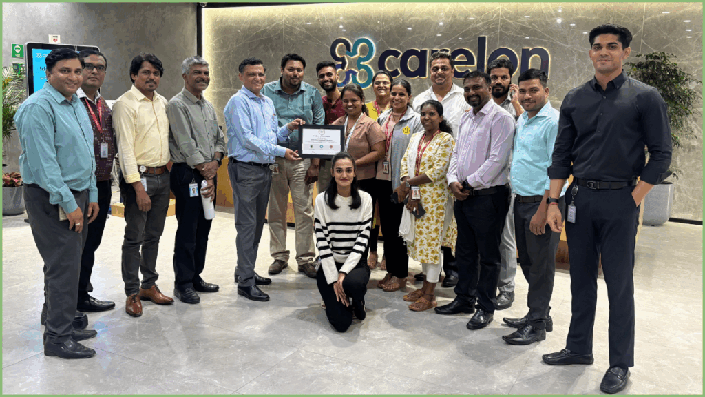 Group photo of Carelon employees and Green Tuesday representatives at the Bengaluru office, with the team holding an accreditation certificate in front of the Carelon logo.